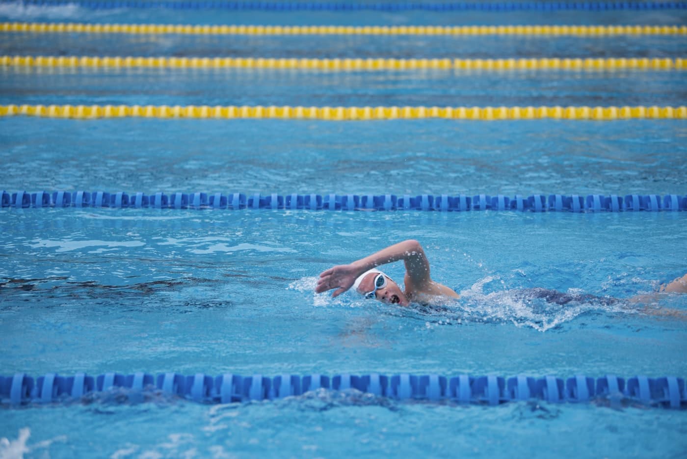 Swimmer mid-stroke performing front crawl with water splashing