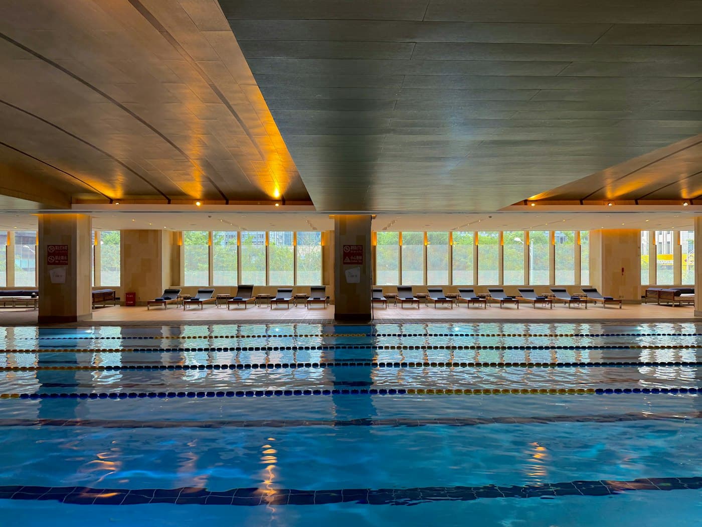 Modern indoor swimming pool with lane markers lit by natural light
